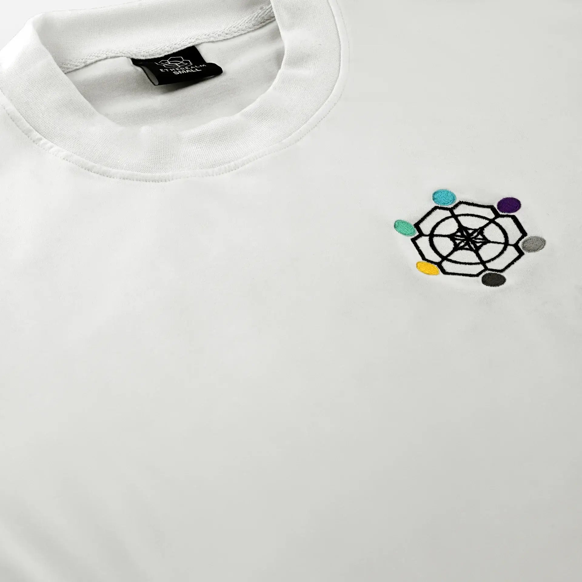 Close-up of ETHER TEE featuring the Etherealm logo on a white T-shirt collar, showcasing premium design and quality.