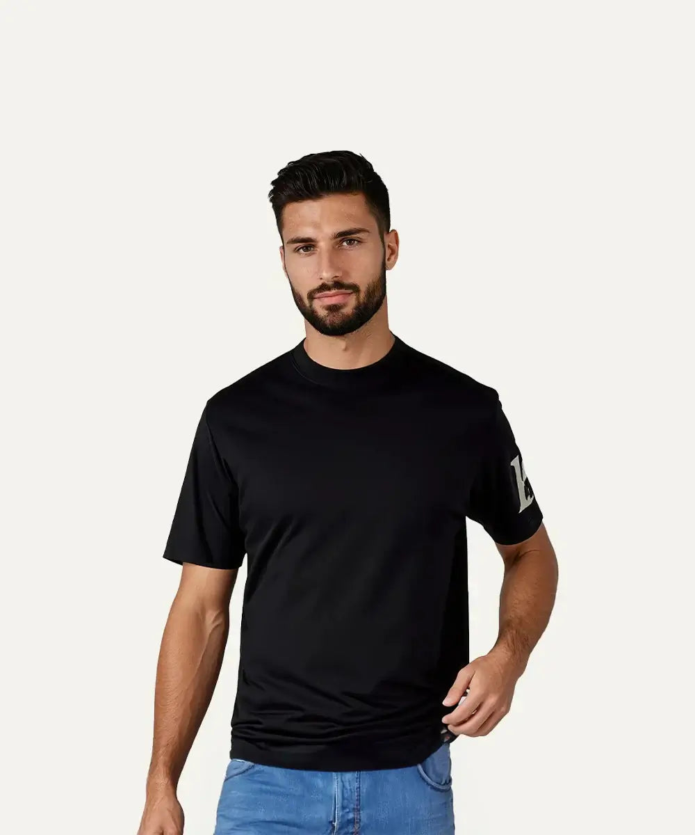 Man wearing a black E T-shirt made from soft cotton, featuring a logo on the sleeve, ideal for everyday comfort.